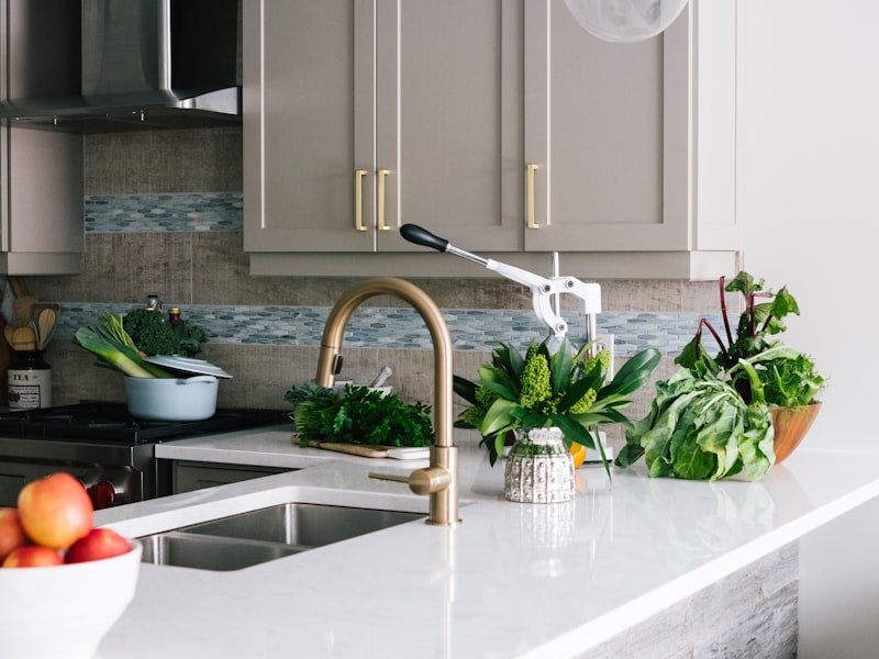 Kitchen with integrated granite backsplash, brass faucet, and sink — full-height stone backsplash fabrication
